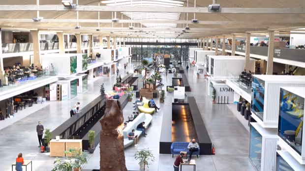 The main hall of Station F, with workspaces lined along a central aisle.